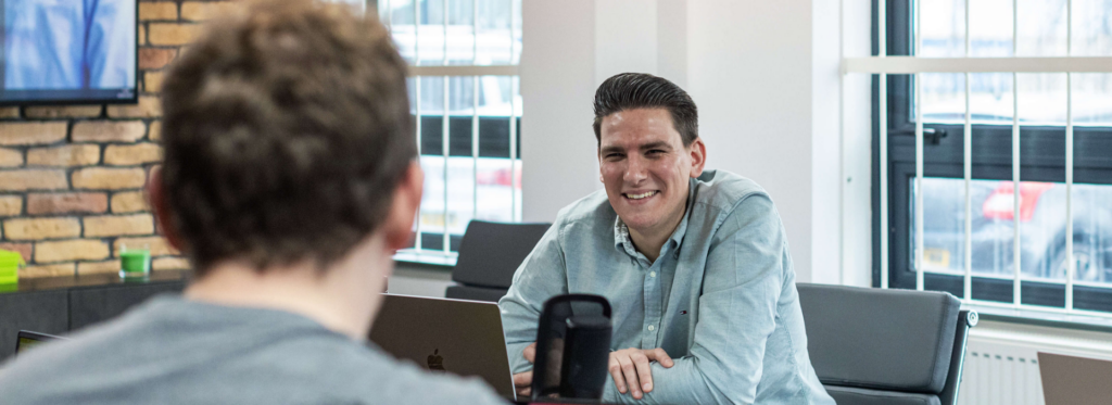 A man smiling sat a a desk in the WebBox office