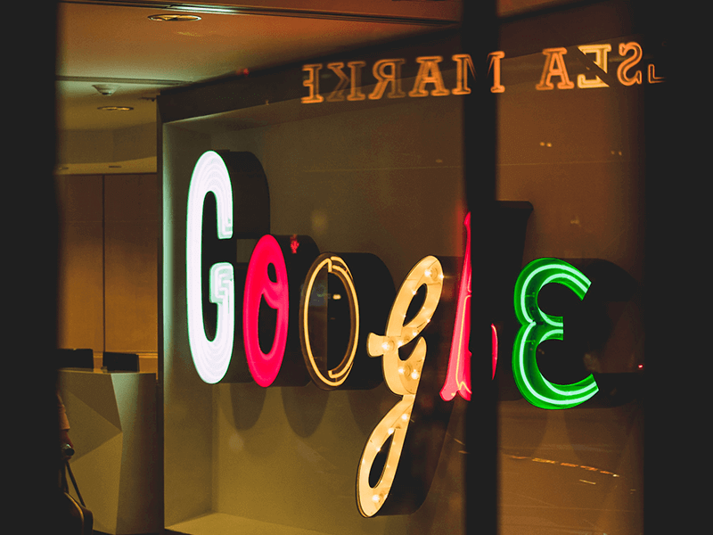 Illuminated Google sign in various colors and styles displayed in a window.